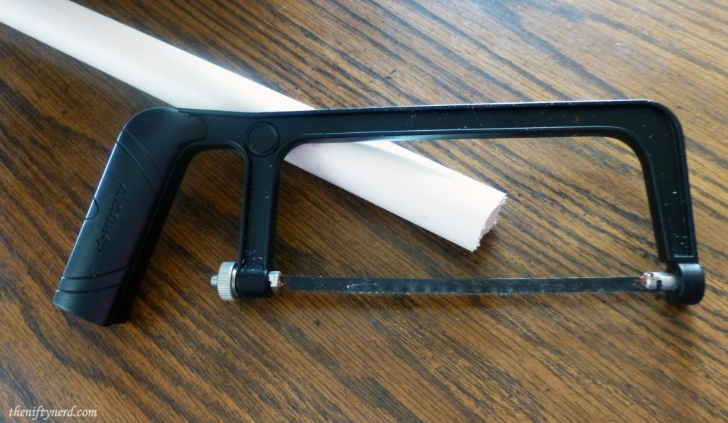 Using a hacksaw to cut PVC pipe