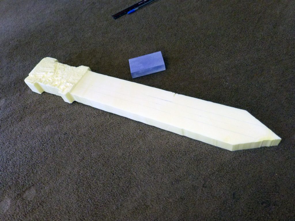 sanding yellow insulation foam into a sword blade
