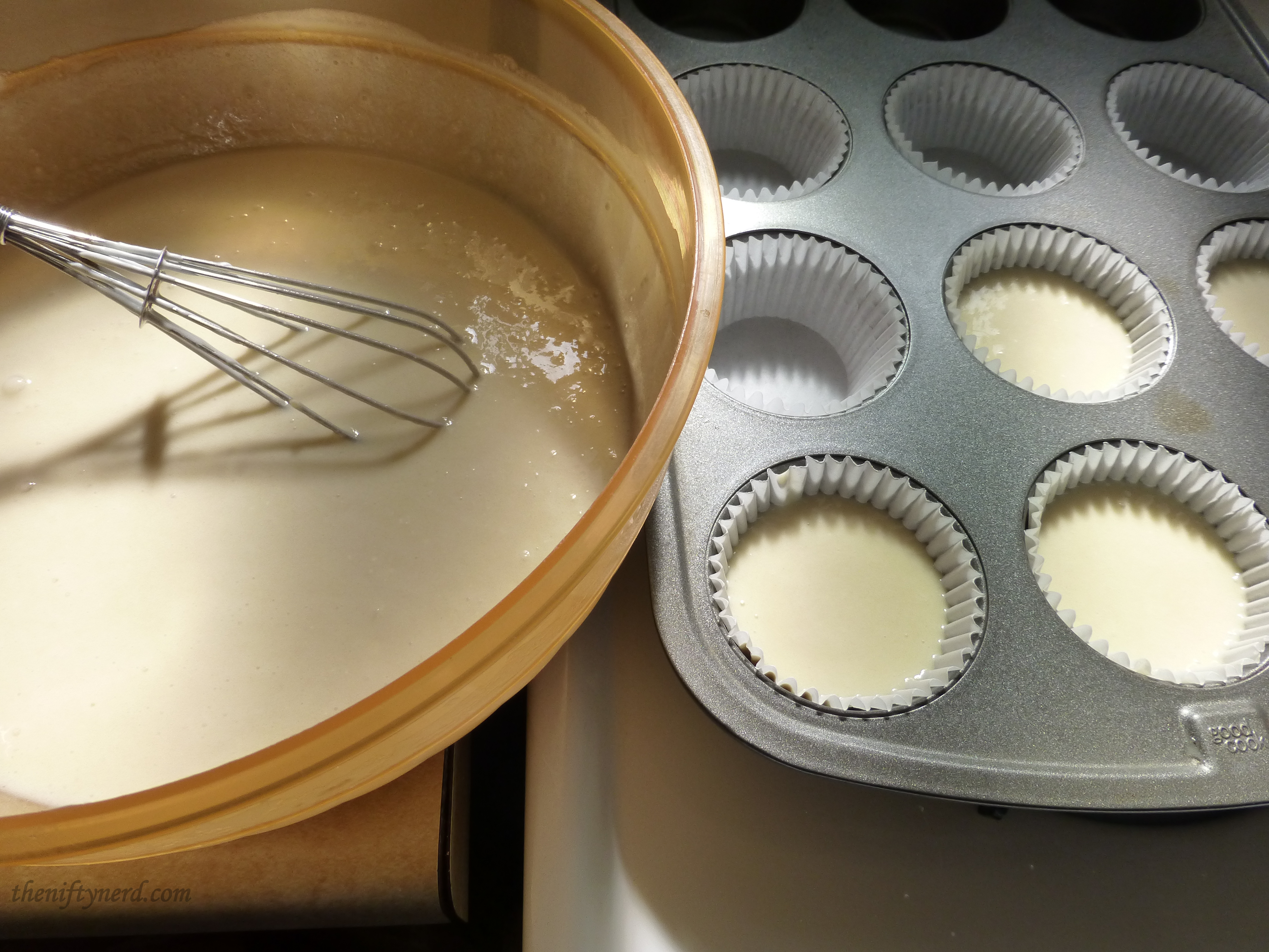 adding cupcake batter to a cupcake tin
